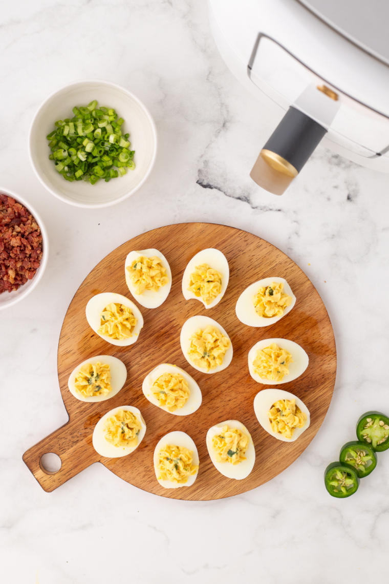 Plate of finished air fryer deviled eggs garnished with paprika, ready to serve as an appetizer.