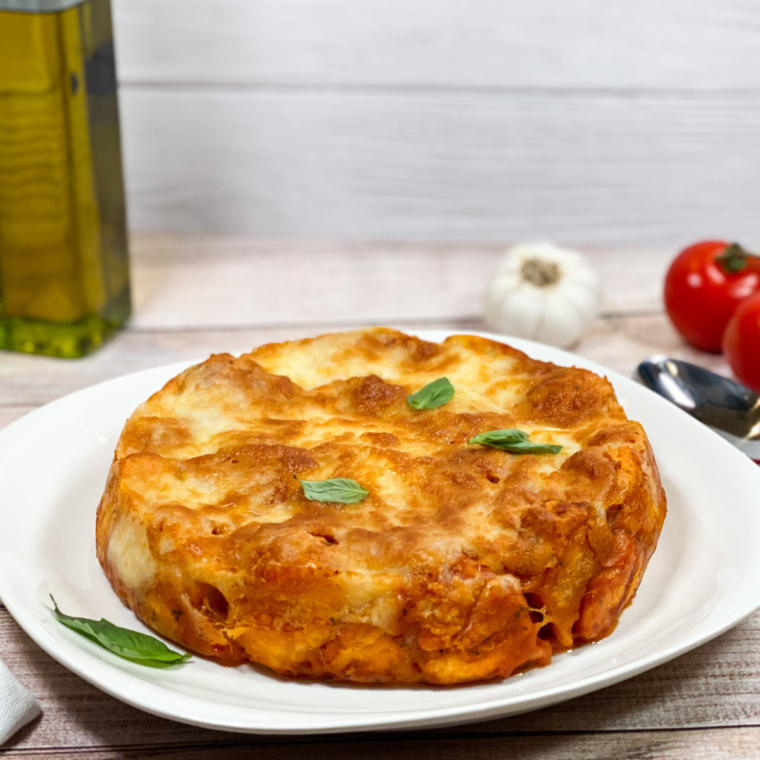 Freshly baked pepperoni pizza casserole in an air fryer basket, with bubbly cheese and crispy pepperoni.