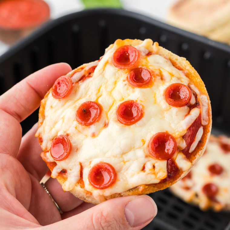 Air fryer English muffin pizzas topped with melted cheese and various delicious toppings, cooked to crispy perfection.