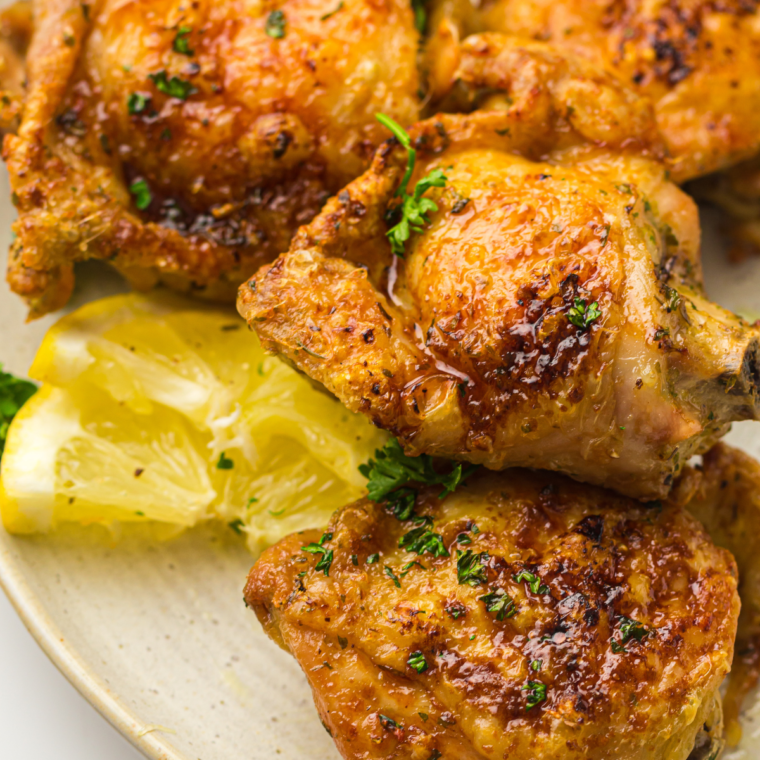 Crispy air fryer ranch chicken thighs served on a plate with fresh herbs.
