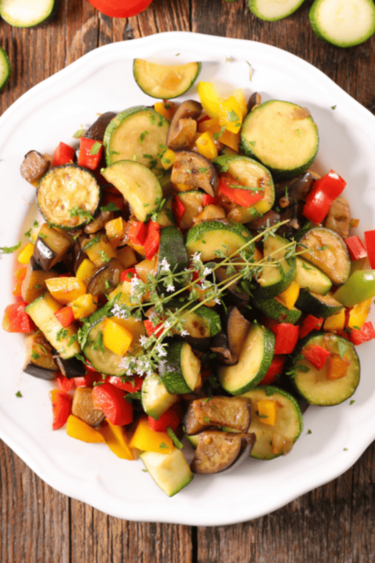 Close up of air fryer squash and zucchini chips with crispy edges and herbs
