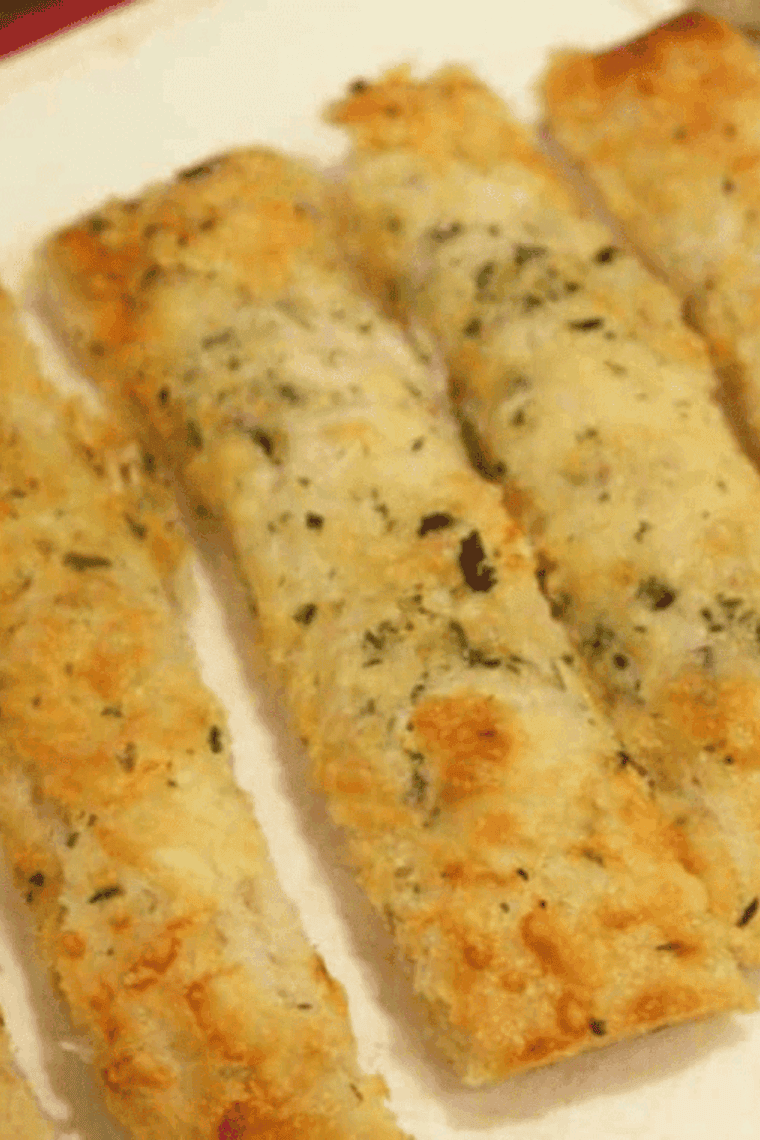 golden brown air fryer cheesy bread sticks topped with melted mozzarella and parsley