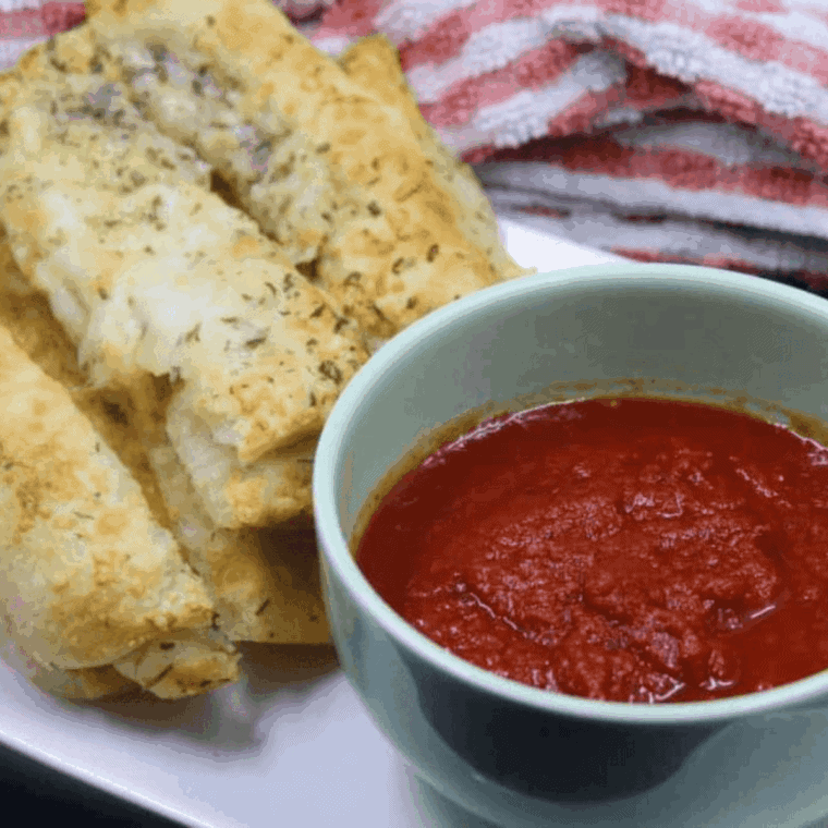 Plate of Easy Air Fryer Cheesy Bread Sticks with dipping sauce.