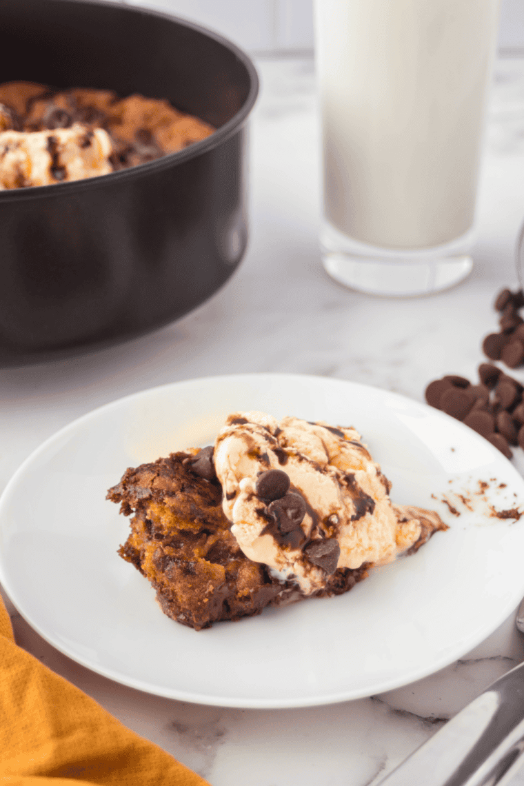 Freshly baked, gooey chocolate chip skillet cookie in an air fryer-safe pan, golden brown and loaded with melted chocolate chips.