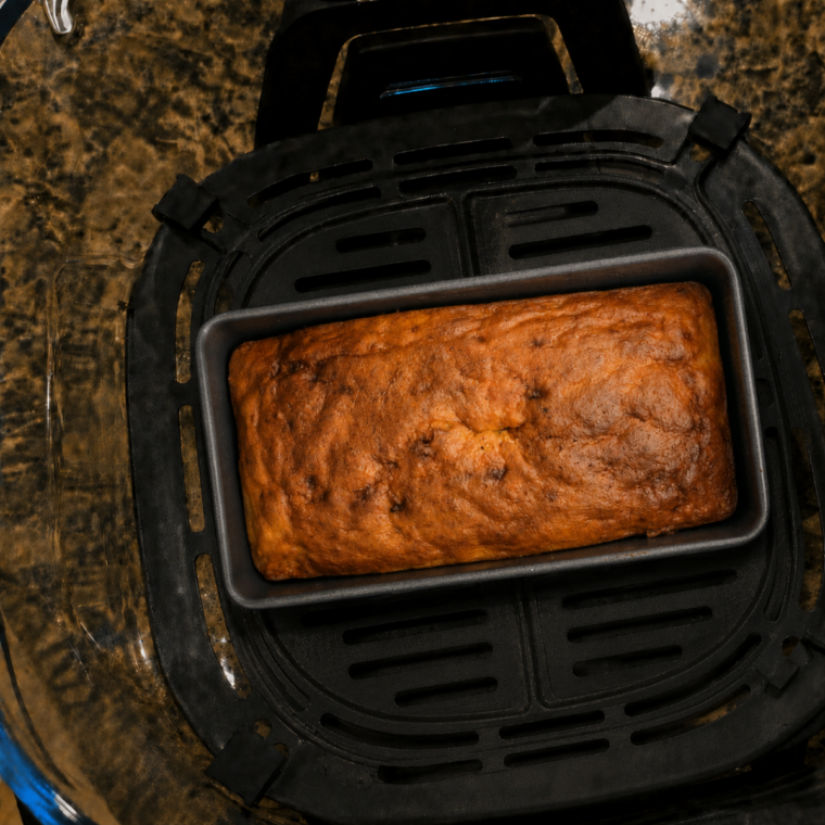 Risen golden banana bread in a small loaf pan removed from the Ninja Crispi