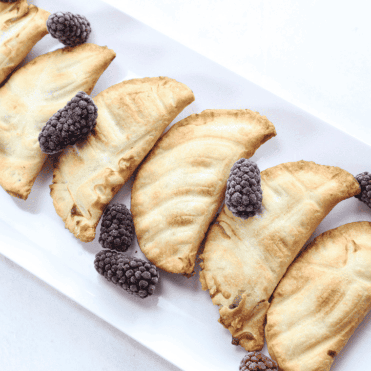 Golden air fryer blueberry hand pies with flaky crust, juicy blueberry filling, and vanilla glaze