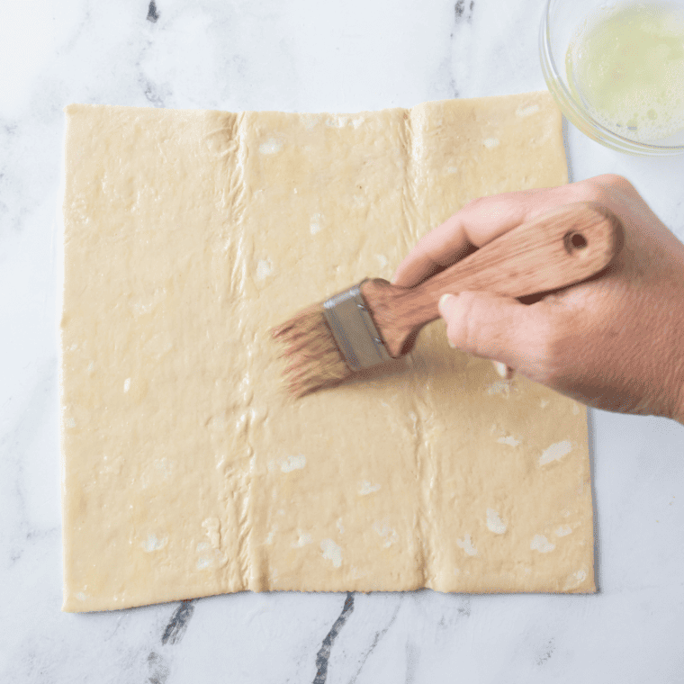 Laying out the puff pastry on a gentle floured surface.