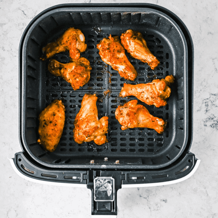 Cooked Air Fryer Chinese Salt and Pepper Chicken Wings in the air fryer basket.
