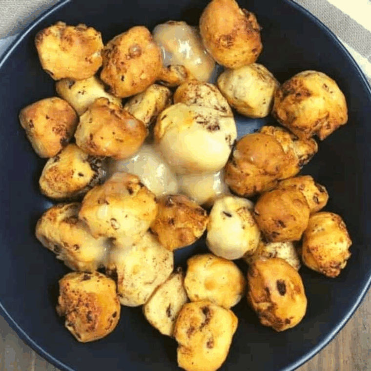 Golden Air Fryer Cinnamon Roll Bubble Bites drizzled with sweet glaze on a plate.