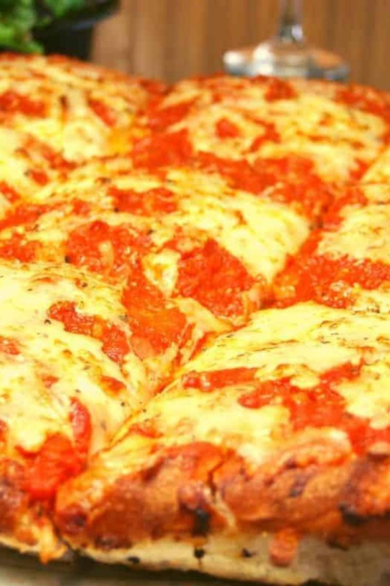 Slice of air fryer Chicago style deep-dish pizza showing the thick cheese layer and buttery crust edge.