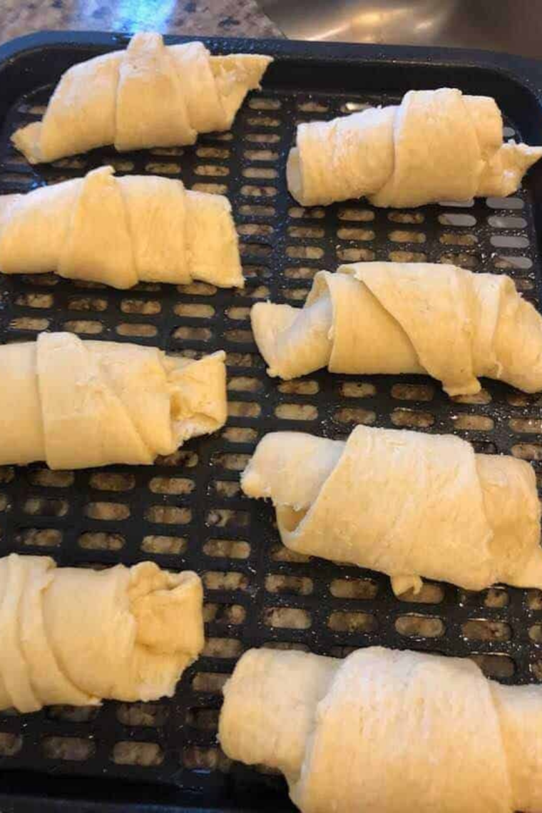 Crescent dough rolled tightly from wide end to tip with filling inside.