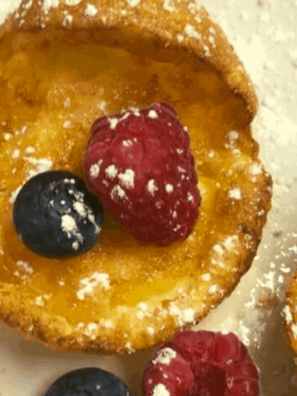 Small puffed mini Dutch pancakes baked in air fryer golden and dusted with powdered sugar
