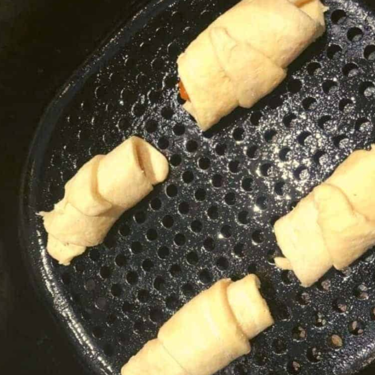 Place the Air Fryer Pumpkin Pie Crescent Rolls into the air fryer basket.