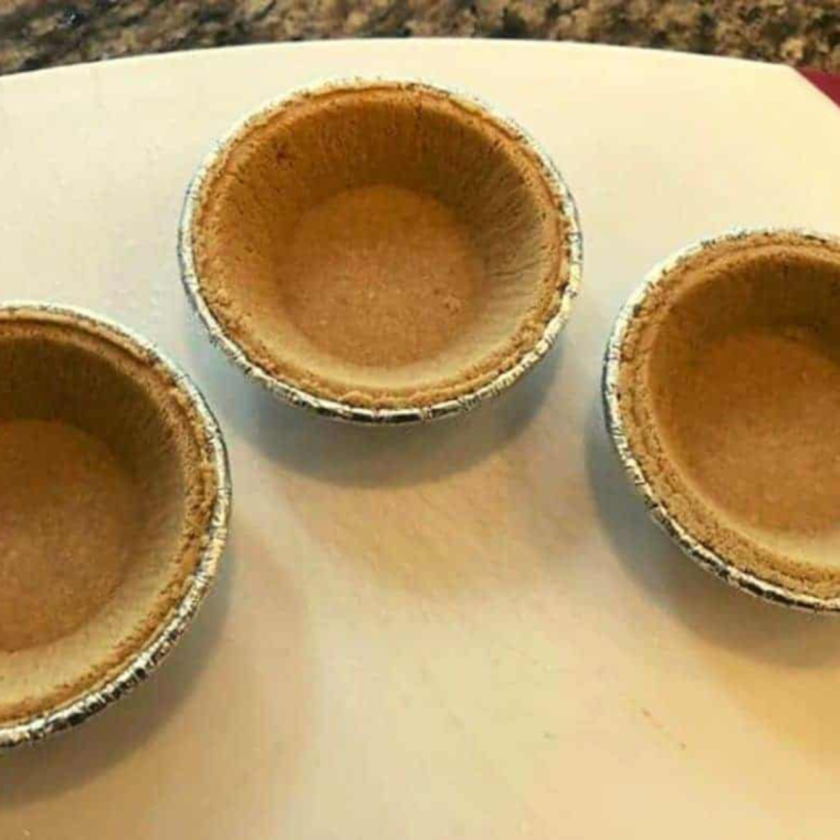 Ingredients for Air Fryer S'mores Pies laid out on a countertop, including graham crackers, chocolate, and marshmallows.