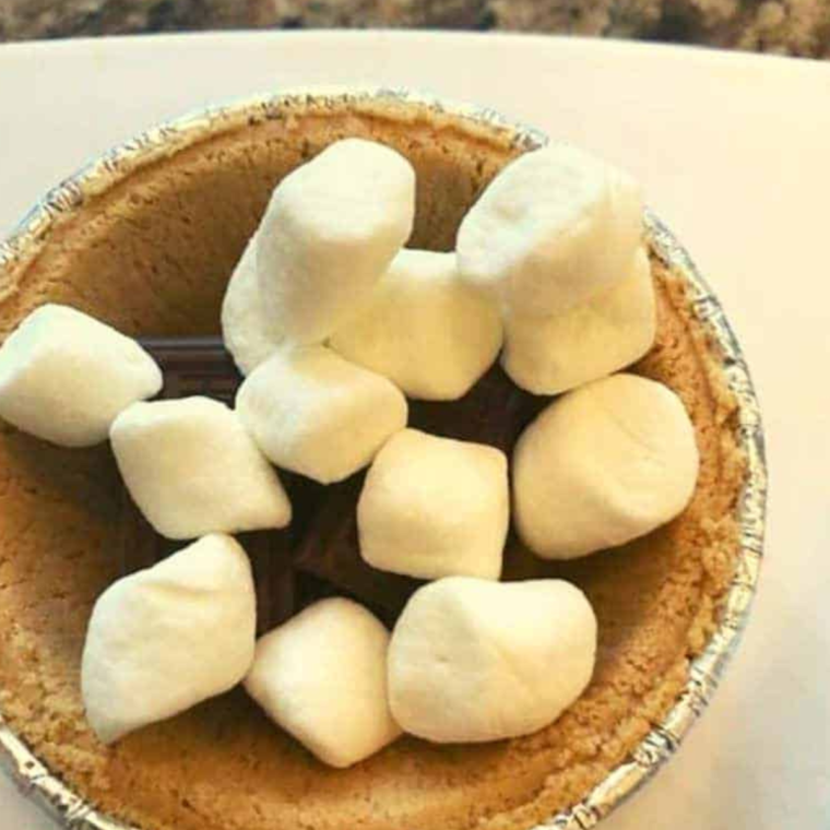 Air Fryer S'mores Pie cooking in the air fryer, showing the cooking process and golden color.