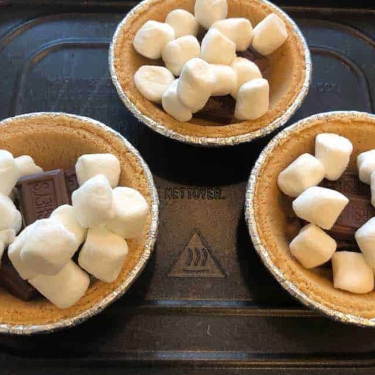 Air Fryer S'mores Pie served on a plate with a side of graham cracker crumbs and chocolate drizzle.