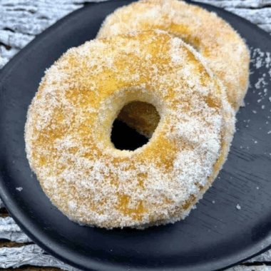 Golden Cinnamon Sugar Air Fryer Biscuit Donuts coated in cinnamon sugar on a plate.