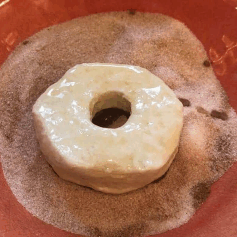 Place the butter coated donut into the cinnamon sugar mixture.