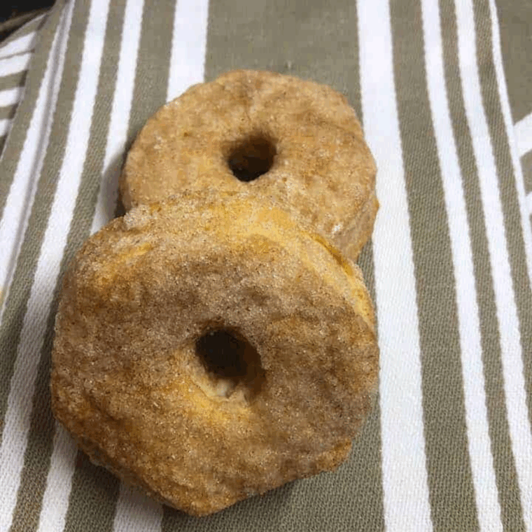Golden Cinnamon Sugar Air Fryer Biscuit Donuts coated in cinnamon sugar on a plate.