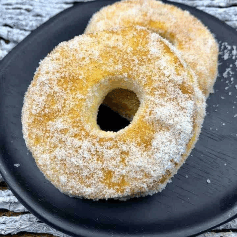 Golden Cinnamon Sugar Air Fryer Biscuit Donuts coated in cinnamon sugar on a plate.