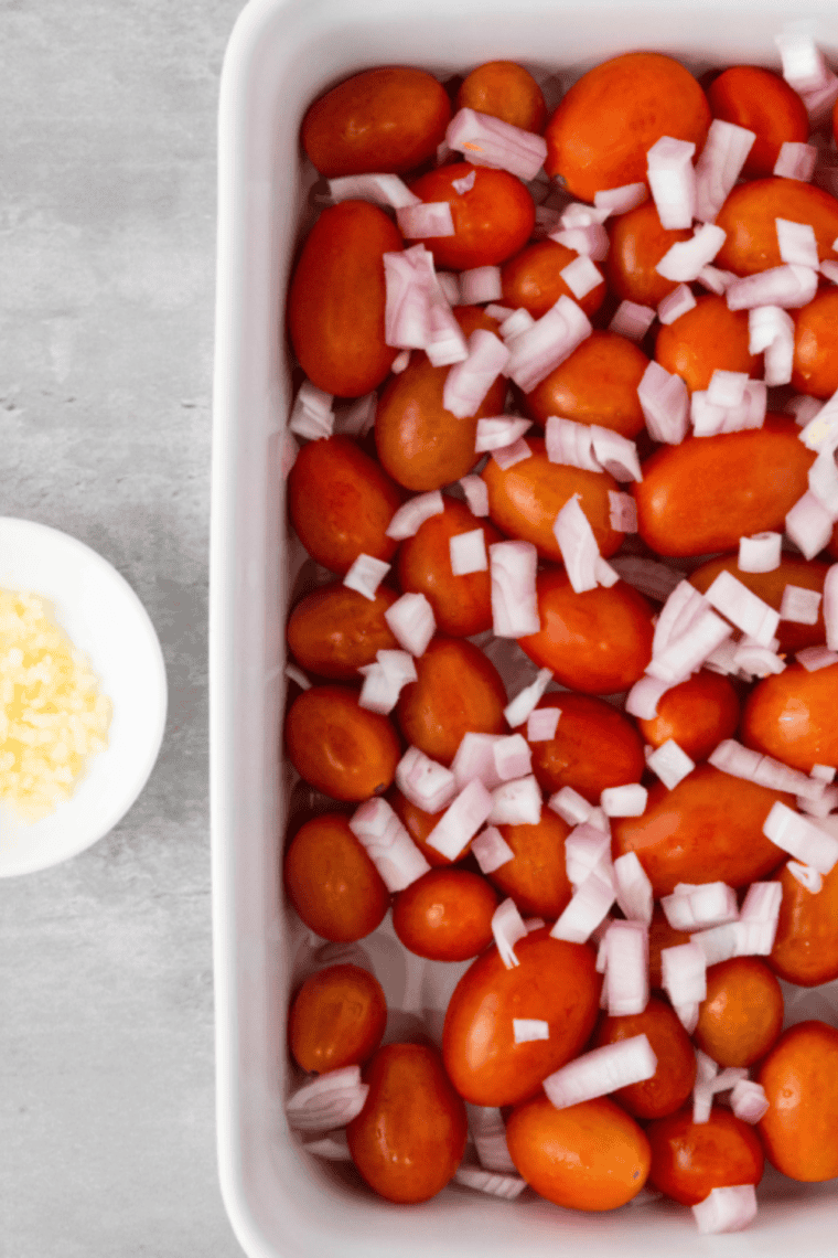 Combine cherry tomatoes, chopped shallot, minced garlic, and olive oil in a baking dish, tossing to coat evenly.