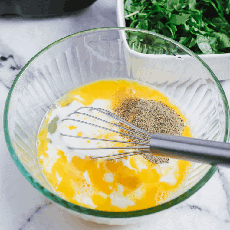 Whisk eggs, milk, salt, and pepper in a bowl, preheating air fryer to 400&deg;F.