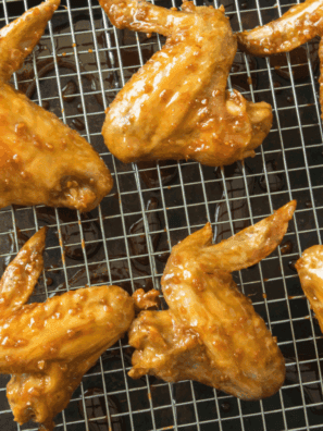 Crispy Jack in the Box-style chicken wings served on a plate with dipping sauce and garnished with herbs.