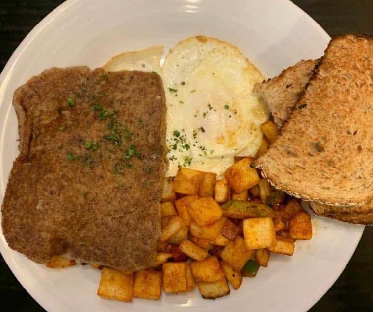 What Is Scrapple?

Scrapple is a traditional American food product that originated in the Pennsylvania, Dutch, and Mid-Atlantic regions of the United States. It is often described as a type of pork-based meatloaf or sausage patty. Scrapple is typically made from pork scraps, such as the head, heart, liver, and other leftover parts, combined with cornmeal and various spices like sage, thyme, and black pepper. The mush of pork scraps is then formed into a loaf, cooked until solidified and sliced into individual servings. Scrapple is known for its crispy exterior and soft, savory interior and is often pan-fried until golden brown before serving. It's a popular breakfast dish in some areas and is enjoyed with condiments like ketchup or maple syrup. While it may not be to everyone's taste due to its unique ingredients, it holds a special place in the culinary traditions of the regions where it's popular.



Can You Air Fry Scrapple?
​

Yes, you can air fry scrapple to achieve a crispy and delicious result. Air frying scrapple is a convenient way to enjoy this regional delicacy with less mess and a perfectly crispy texture.



Why Air Fry Scrapple?
Crispy Texture: Air frying allows you to achieve a crispy scrapple exterior without excessive oil. The hot circulating air in the air fryer helps create that desirable crunch.

Healthier Option: By air frying scrapple, you can significantly reduce the amount of oil used compared to traditional frying methods. It's a healthier alternative for those who enjoy scrapple without excess grease.

Convenience: Air fryers are known for their convenience. They preheat quickly, and cooking is generally faster than an oven or stovetop. This makes air frying scrapple a time-saving option for busy mornings.

Reduced Mess: Air frying minimizes splattering and eliminates the need for excessive cleanup since there's no oil bubbling in a pan. This is especially helpful when dealing with foods that release grease when cooked.

Even Cooking: Air fryers distribute heat evenly, ensuring that both sides of the scrapple slices are cooked uniformly. You won't need to worry about flipping them constantly to prevent burning or uneven cooking.

​

Ingredients Needed For Air Fried Scrapple
With these essential ingredients and the magic of air frying, you can enjoy a scrumptious plate of scrapple with a perfect crispy texture.


Remember the step-by-step directions and detailed ingredient list are below in the printable recipe card, at the bottom of the post, at the bottom of the post, and the nutritional information.

Scrapple Slices: The star of the dish, scrapple is a savory, pork-based breakfast meat typically formed into slices.

Cooking Spray: A light coating of cooking spray is used to prevent sticking and help achieve that crispy exterior.

 



How To Cook Scrapple In The Air Fryer
Cooking scrapple has never been easier than in the air fryer; follow this step-by-step guide. 



Preheat Your Air Fryer: Preheat your air fryer to 375 degrees F (190°C) for about 3-5 minutes.

Slice the Scrapple: Cut the Scrapple into slices of your desired thickness. Generally, slices around 1/4 to 1/2 inch thick work well; you can also cut the scrapple into scrapple fries.

Arrange in the Air Fryer Basket: Place the scrapple slices in a single layer in the air fryer basket. Make sure they aren't touching to allow for even cooking.

Air Fry: Cook the scrapple at 375°F (190°C) at a cook time of 8-10 minutes. You can flip the slices halfway through the cooking time to ensure both sides get crispy.

Check for Doneness: When done, the scrapple should be golden brown and crispy. Cooking times may vary slightly depending on your air fryer model, so keep an eye on it during the last few minutes.

Serve: Once the scrapple is cooked to your desired crispiness, remove it from the air fryer and let it cool for a minute or two. Then, serve it hot with your favorite breakfast sides, such as eggs, toast, or pancakes.

Air frying scrapple is a fantastic way to achieve that perfect crispy texture without excess oil. Enjoy your scrumptious breakfast!



Pro Tips For Making Crispy Scrapple In The Air Fryer
Here are some pro tips to ensure your air-fried scrapple turns out delicious:

Preheat the Air Fryer: Preheating the air fryer ensures that the scrapple will start cooking immediately, giving it a crispy texture.

Don't Overcrowd: Make sure not to overcrowd the air fryer basket. Place the scrapple slices in a single layer with some space between them for even cooking.

Spray with Cooking Oil: Lightly spray or brush the scrapple slices with cooking oil before placing them in the air fryer. This helps enhance the crispiness.

Flip Halfway Through: Flip the scrapple slices halfway through the cooking time to achieve even browning and crispness on both sides.

Check for Doneness: Keep an eye on the scrapple during the last few minutes of cooking. Cooking times may vary depending on the thickness of the slices and your air fryer model. Please remove it from the air fryer when it reaches your desired level of crispiness.

Serve with Condiments: Scrapple pairs well with ketchup, maple syrup, or apple butter. Consider offering these on the side for dipping or drizzling.

Experiment with Seasonings: Before air-frying, you can season the scrapple slices with herbs, spices, or seasoning blends for added flavor.

Following these tips, you can enjoy perfectly crispy air-fried scrapple for a delightful breakfast or brunch.


What is scrapple made of? Scrapple is typically made from pork, specifically the scraps and trimmings of the pig, such as the head, heart, liver, and other organs. These ingredients are combined with cornmeal and spices.

Is scrapple the same as sausage or bacon? No, scrapple is a distinct pork product with unique flavor and texture. While sausages and bacon are also made from pork, they have different ingredients and preparation methods.

How is scrapple traditionally served? Scrapple is often sliced and fried until crispy, then served as a breakfast side dish. Eggs, toast can accompany it, or a breakfast sandwich.

Can you air fry scrapple? Yes, you can air fry scrapple. Cooking scrapple in an air fryer can yield crispy results without adding excess oil.

What spices are typically used in scrapple? Spices used in scrapple can vary, but common seasonings include sage, thyme, black pepper, and sometimes red pepper flakes. The specific spice blend may vary by region or personal preference.

Can you freeze scrapple? Yes, scrapple can be frozen for later use. Slice it into portions, wrap each portion tightly in plastic or aluminum foil, and store them in an airtight container or freezer bag.

Is Scrapple gluten-free? Traditional scrapple recipes contain cornmeal, which is a gluten-containing ingredient. However, some manufacturers produce gluten-free scrapple using alternative grains or flour.

How do you reheat leftover scrapple? To reheat leftover scrapple, you can use methods like frying it in a skillet, baking it in the oven, or air frying until heated and crispy.

Where can I buy scrapple? You can typically find scrapple at your local grocery store, butcher shops, farmers' markets, online retailers, specialty food stores, and some restaurants, especially in regions where scrapple is popular.

 What are some scrapple recipe ideas? Scrapple can be used in various recipes, including breakfast sandwiches, scrapple and eggs, scrapple sliders, and even scrapple stuffing for poul



More Air Fryer Recipes