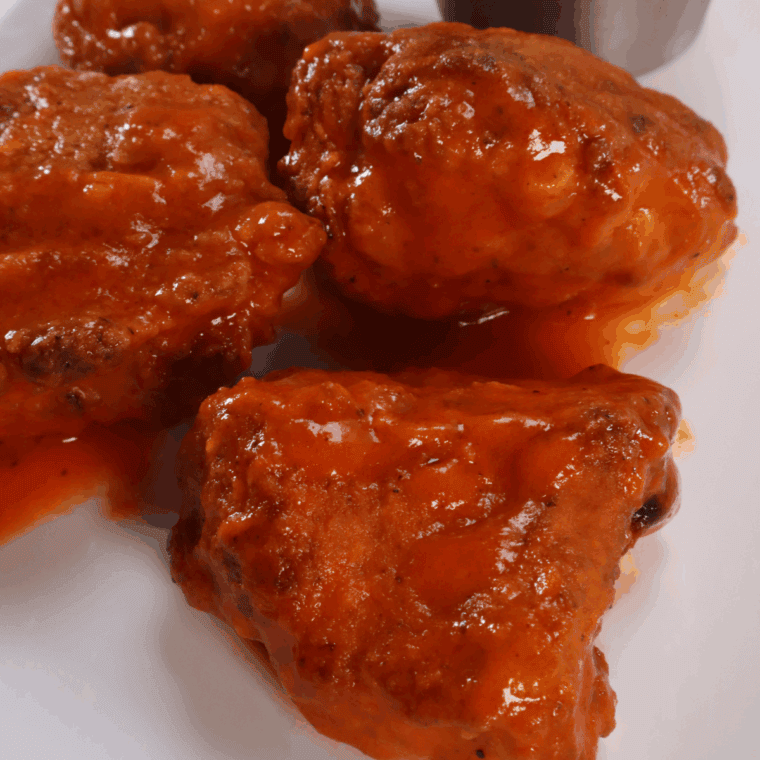 Texas Roadhouse-style boneless buffalo wings coated in spicy sauce, served with ranch and celery sticks.