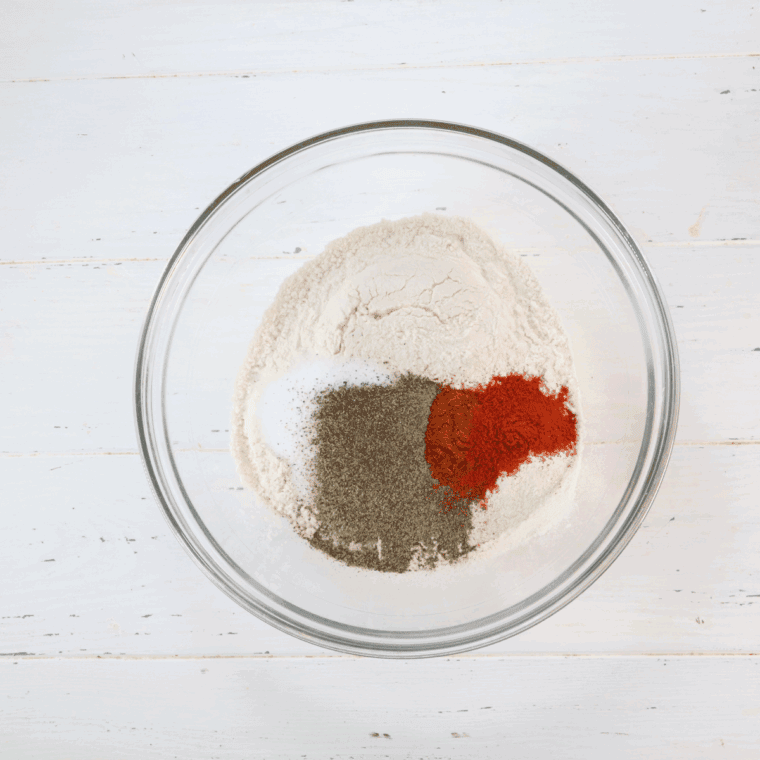 Two bowls side by side—one with whisked eggs and milk, the other with seasoned flour mixture.