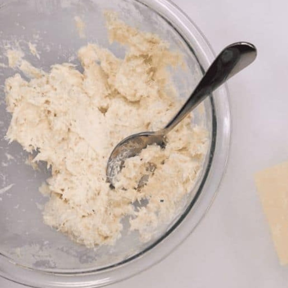 A bowl of crab mixture with cream cheese, green onions, and seasonings, prepared for filling the wontons.