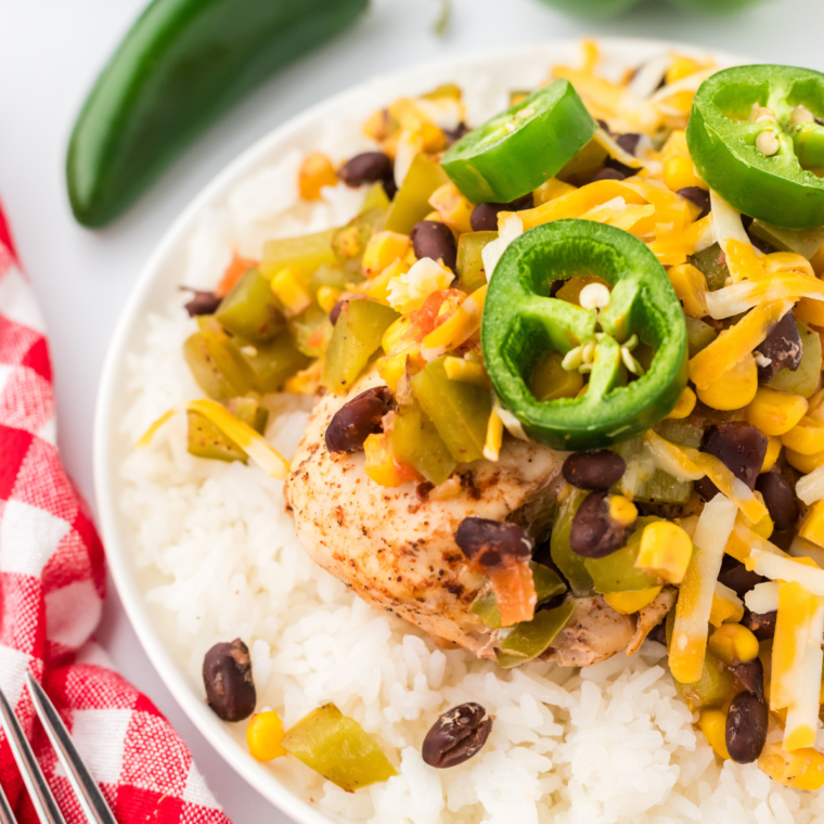 Air Fryer Mexican Chicken Foil Packet with seasoned chicken, veggies, and fresh lime wedges on a wooden board.