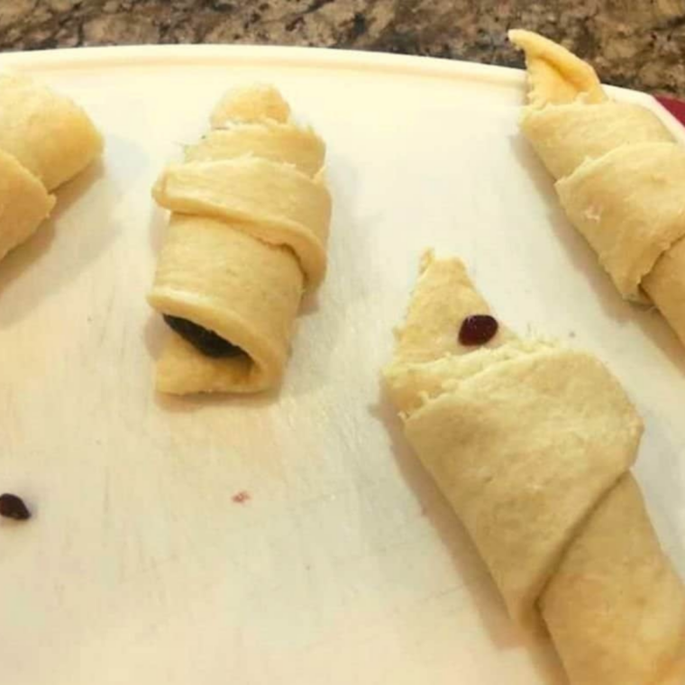 Raspberry jam spooned onto the wide end of crescent dough triangles before rolling.