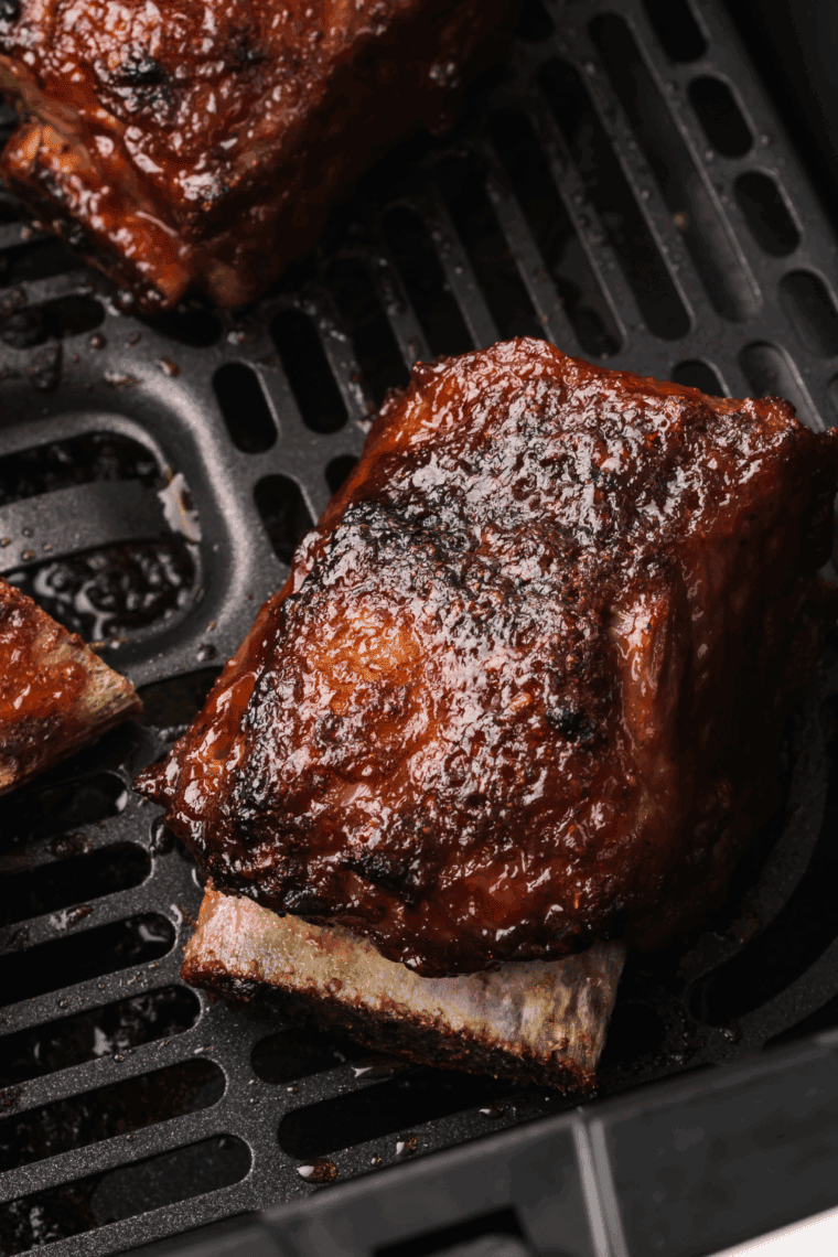 Korean-style air fryer short ribs garnished with sesame seeds and green onions.