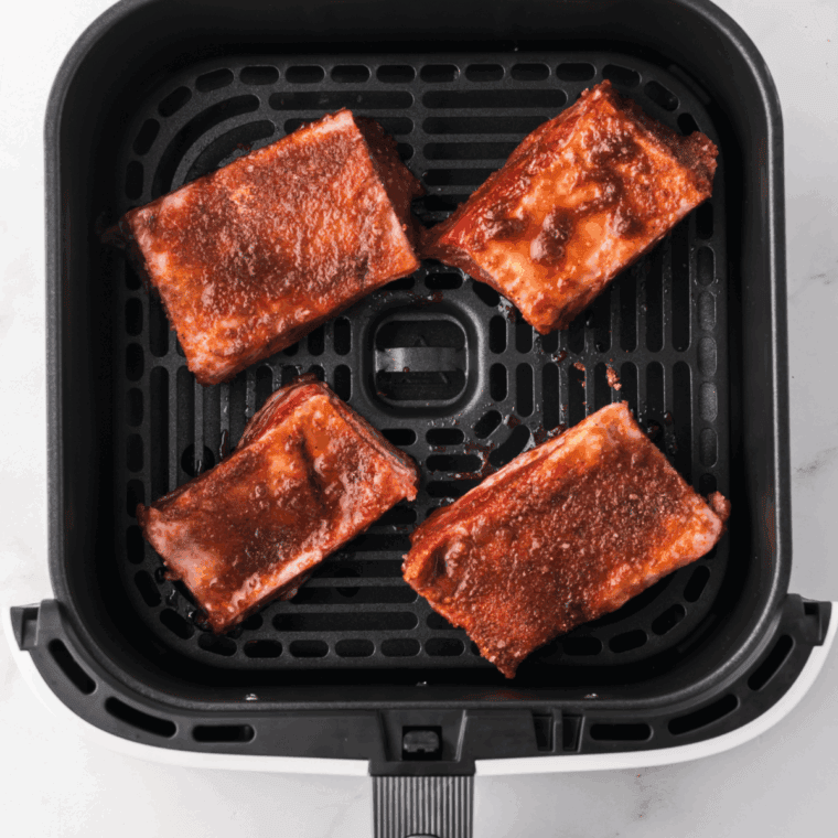 Short ribs marinating in soy sauce, brown sugar, garlic, and spices in a large bowl.