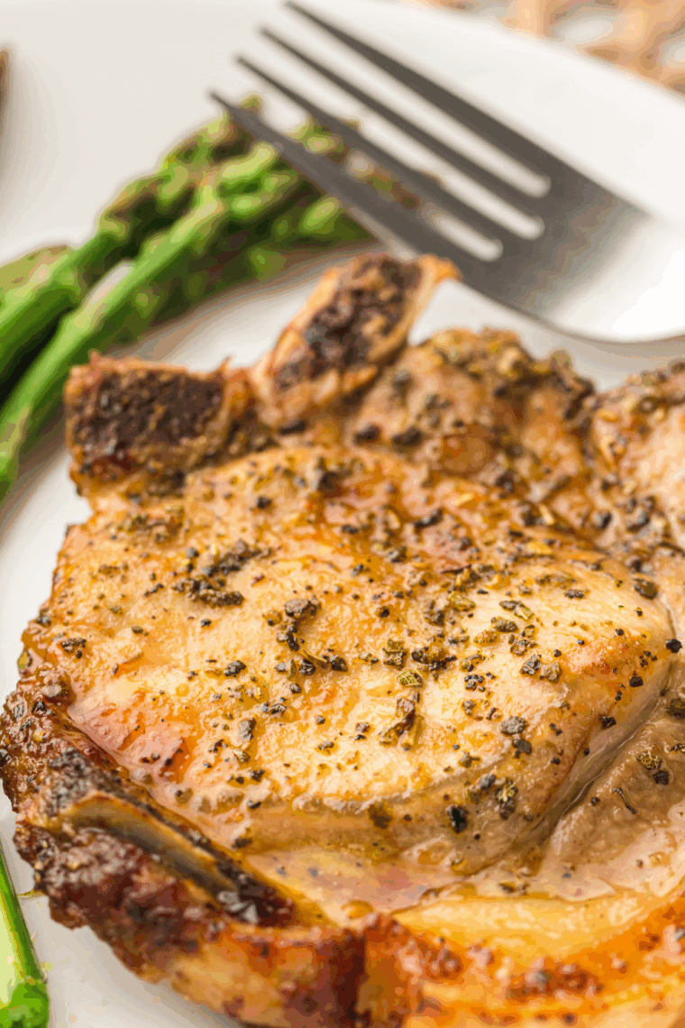 Juicy Mexican pork chops seasoned with spices, served on a plate with garnish.