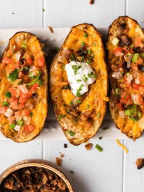 Golden brown air fryer frozen potato skins topped with melted cheese and crispy bacon