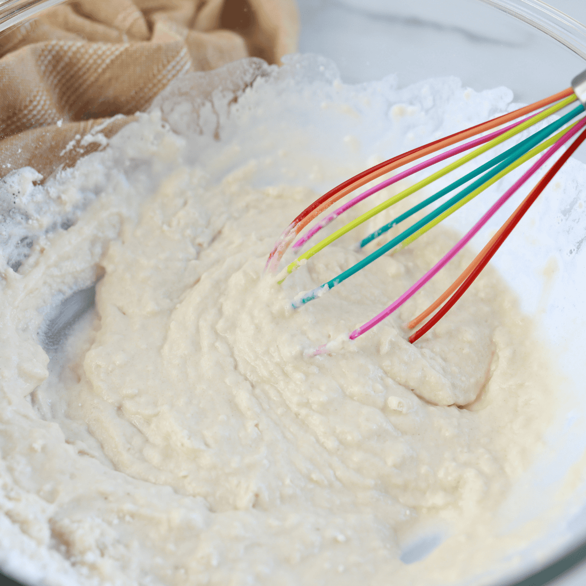 Ingredients needed for How To Make Homemade Waffles In Air Fryer in mixing bowl, with whisk.