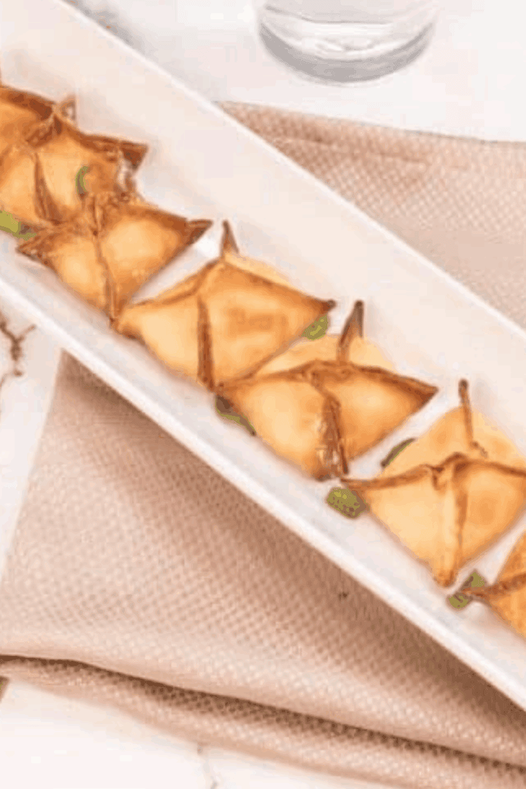 Crispy homemade P.F. Chang’s Crab Rangoons served with sweet chili dipping sauce on a white platter.