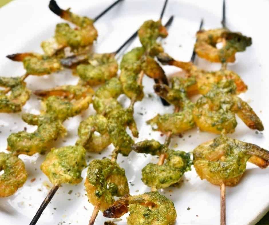 Pour in the basil pesto sauce and mix well, covering the shrimp  As you thread them through the skewer, place them on a greased air fryer oven sheet or in a greased air fryer basket.  Place in the air fryer oven or basket and set the temperature to 400 degrees F for 5 minutes.  Once they are opaque in color pull them out, as you don't want them to overcook.  Plate, serve and enjoy!