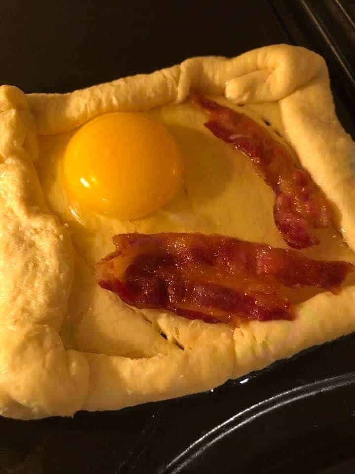 Eggs and bacon on dough cooked