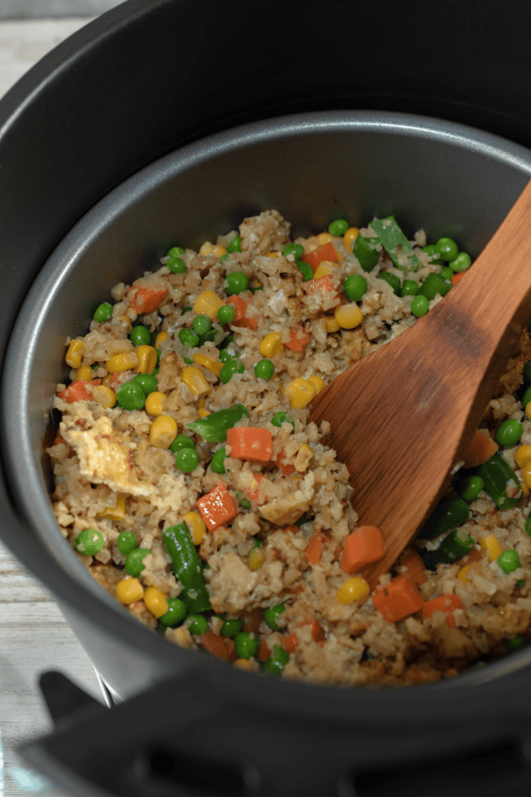 Cooking the Air fryer fried cauliflower rice in the air fryer basket.