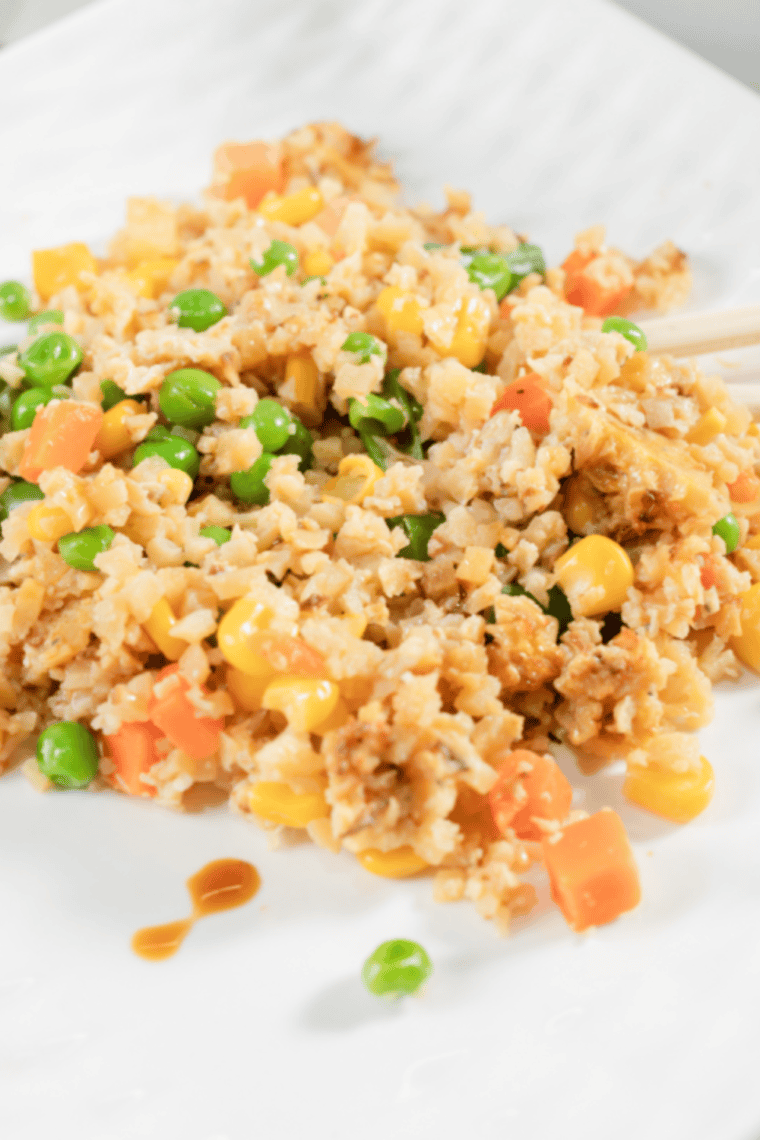 Air fryer fried cauliflower rice with colorful vegetables in a white bowl, light and crispy, ready to serve