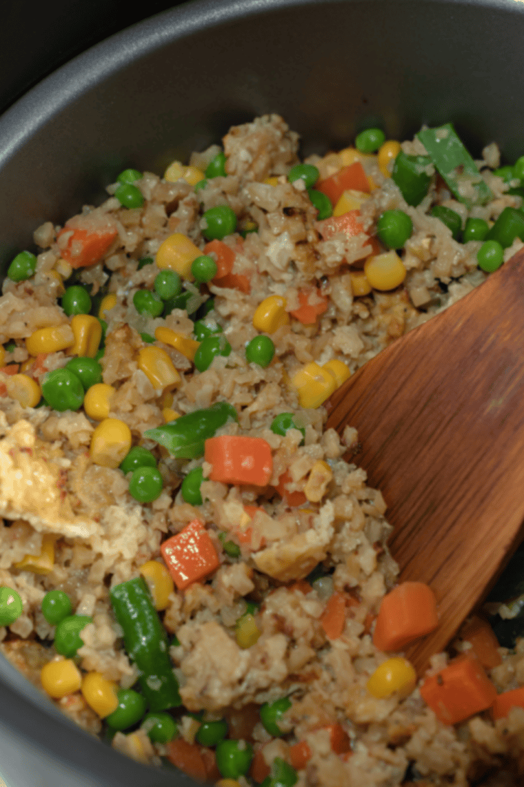 Air fryer fried cauliflower rice with mixed vegetables served hot in a white bowl