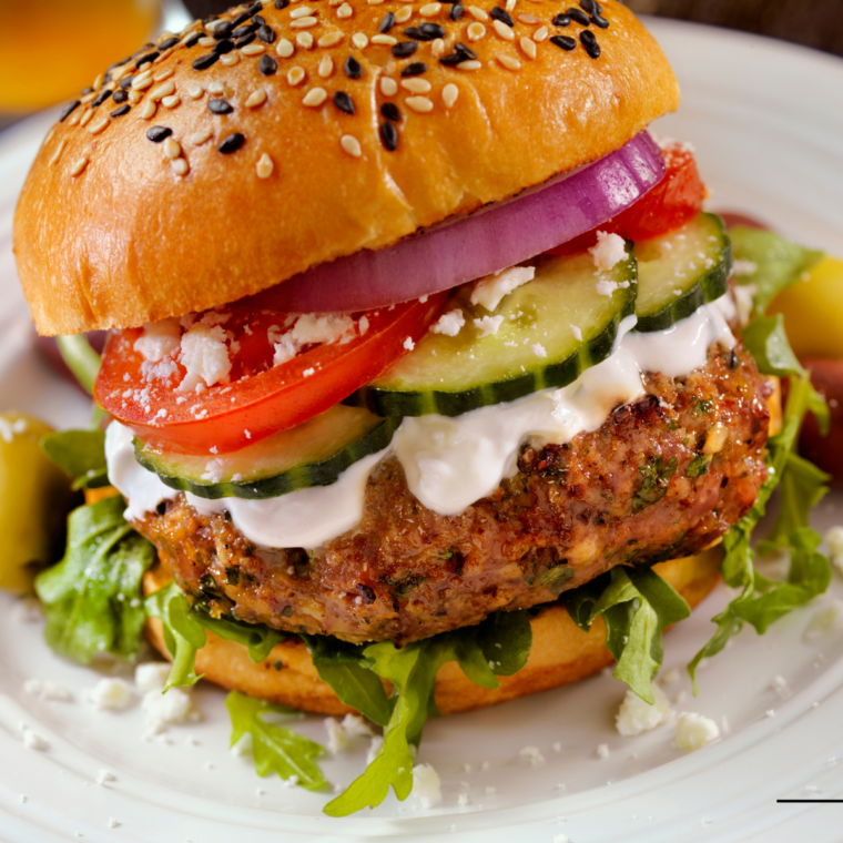 Plated Air Fryer Greek Burger with a side of tzatziki and fresh dill garnish."