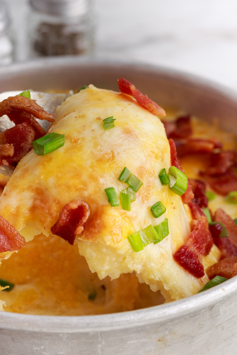 Bowl of creamy air fryer mashed potatoes topped with melted butter smooth fluffy texture easy no-boil potato side dish recipe.