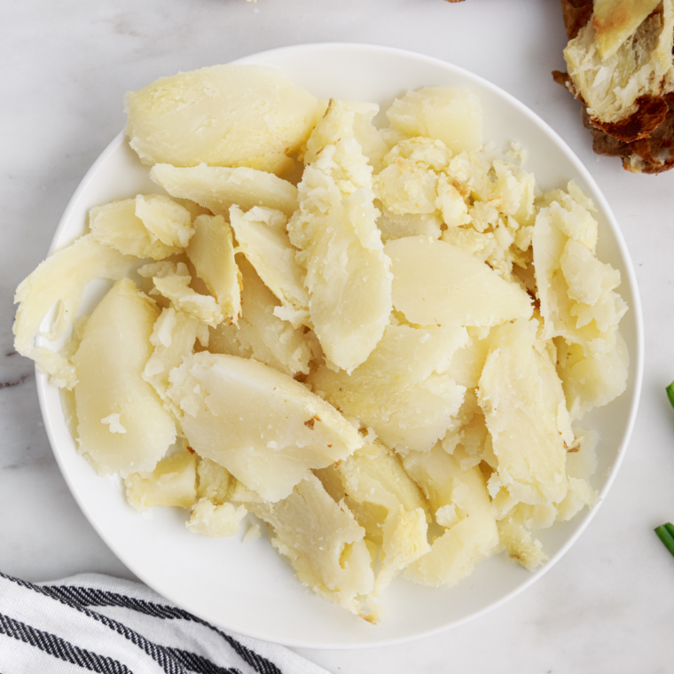 Air fried potatoes resting briefly then cut open and scooped or peeled to remove soft fluffy interior for mashed potatoes preparation.