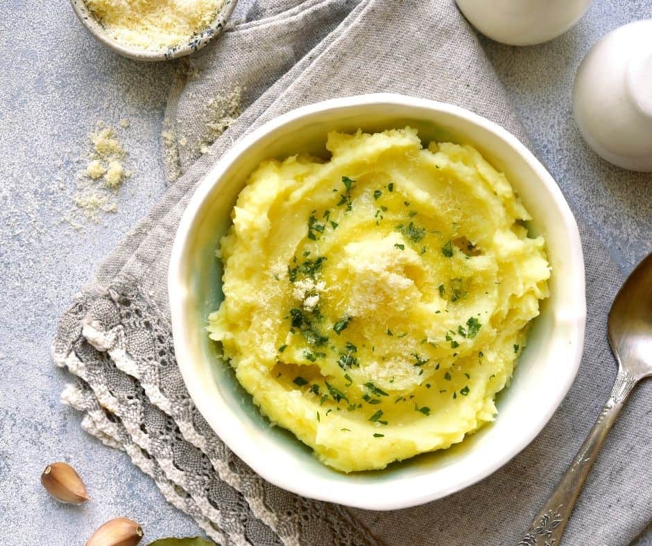 overhead: a bowl of air fryer mashed potatoes with fresh herbs on top