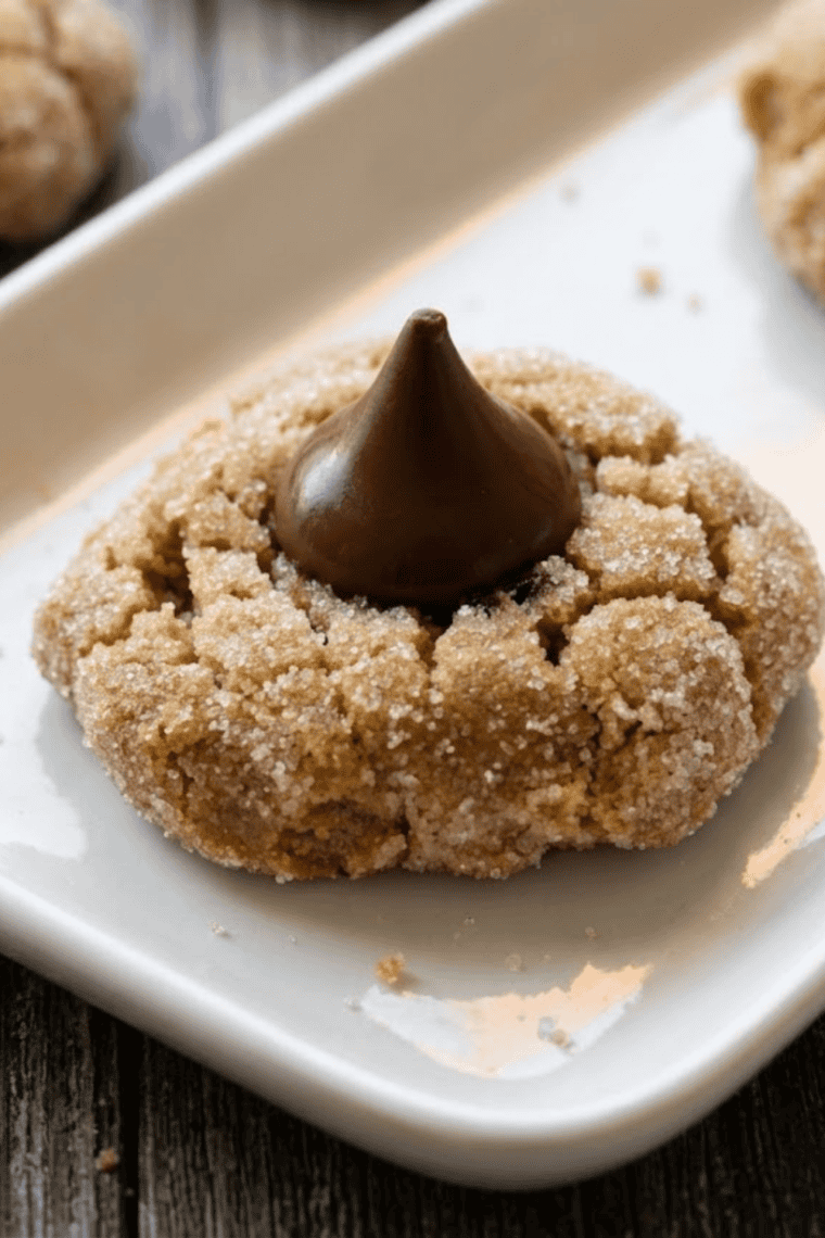 Freshly baked air fryer peanut butter cookies topped with chocolate kisses on a cooling rack.