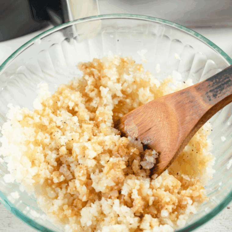 Pouring soy sauce mixture over cauliflower rice and transferring it into a round air fryer-safe cake pan